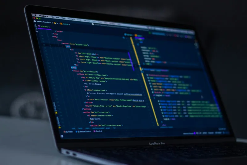 Modern programmer workstation with dark theme IDE displaying clean backend system source code